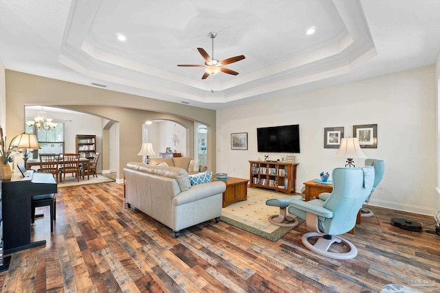 4951 Red Oak Dr, Milton, FL 32583 - living room with crown molding, arched walkways, wood finished floors, ceiling fan with notable chandelier, and a tray ceiling