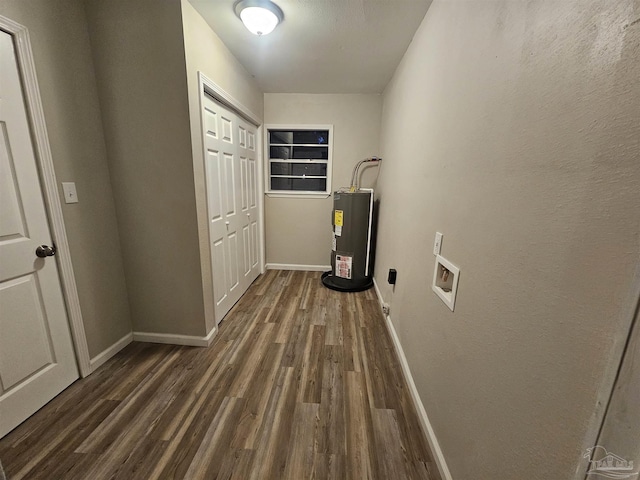 clothes washing area with dark hardwood / wood-style flooring, washer hookup, and water heater