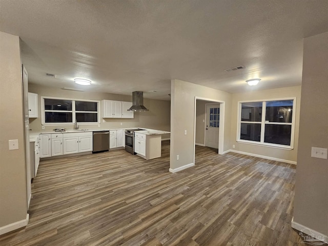 kitchen with extractor fan, stainless steel appliances, sink, and white cabinets