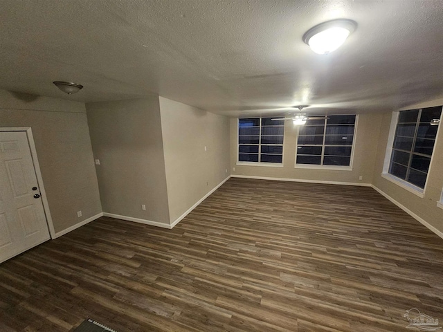 spare room with dark hardwood / wood-style floors and a textured ceiling