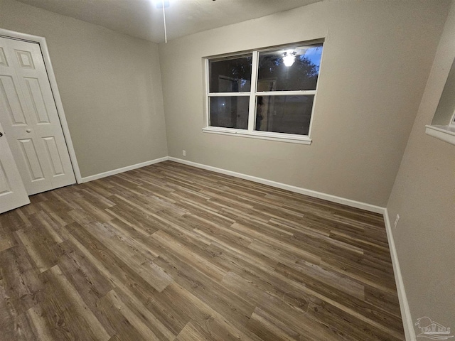 unfurnished room featuring dark wood-type flooring