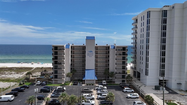 view of property with a water view and a view of the beach