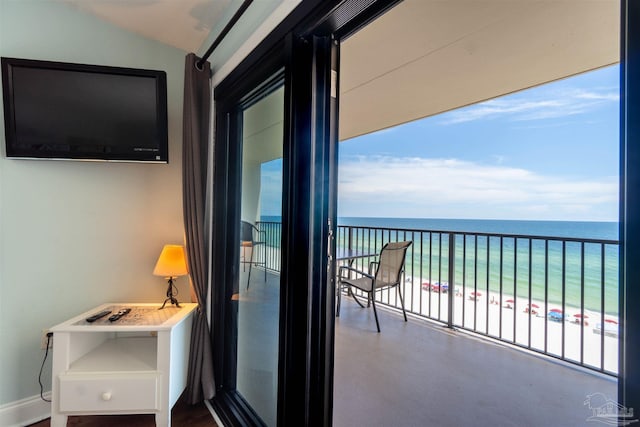 balcony featuring a beach view and a water view