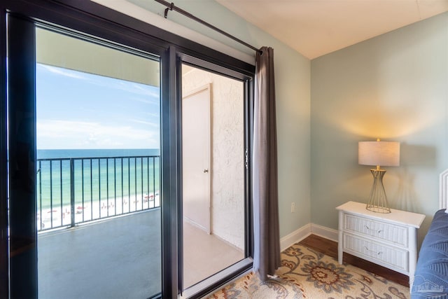 doorway with hardwood / wood-style flooring and a water view