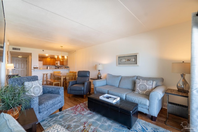 living room with hardwood / wood-style floors and a chandelier