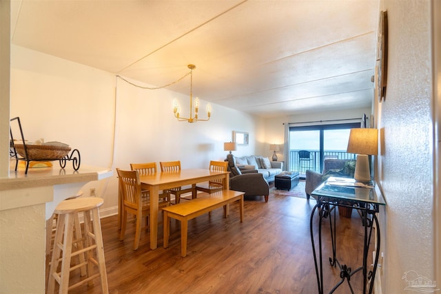 dining space with dark wood-type flooring and a chandelier