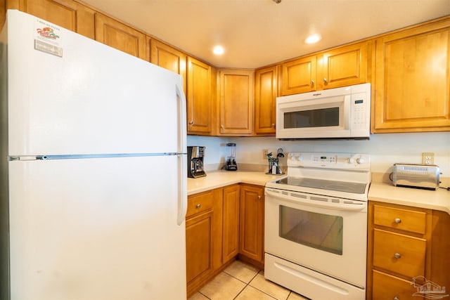 kitchen featuring light tile patterned floors and white appliances