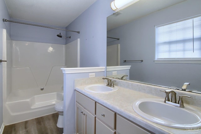 full bathroom featuring vanity, toilet, washtub / shower combination, and hardwood / wood-style floors