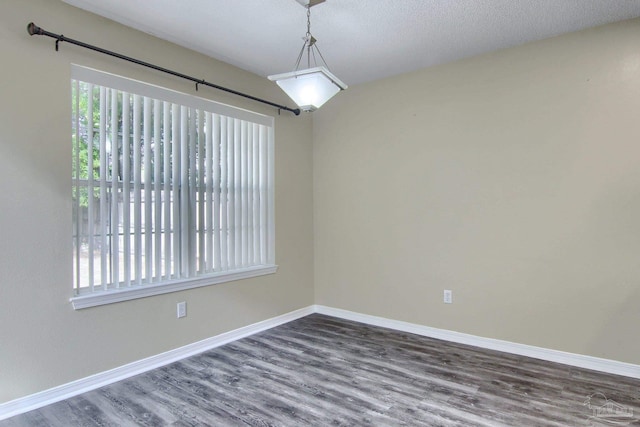 empty room featuring dark wood-type flooring and a textured ceiling