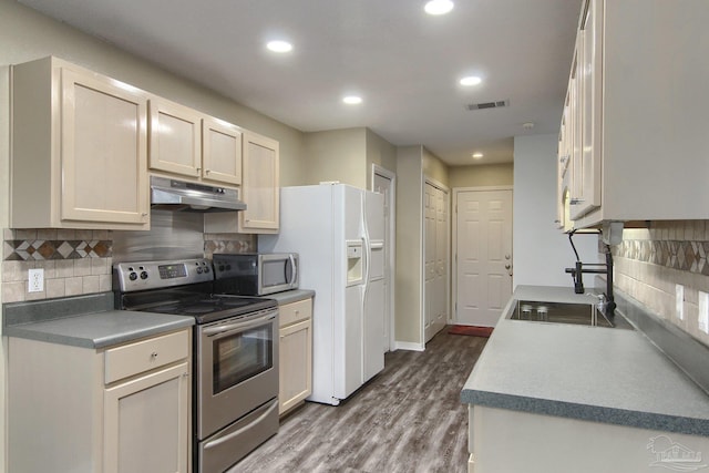 kitchen featuring sink, dark wood-type flooring, stainless steel appliances, and backsplash