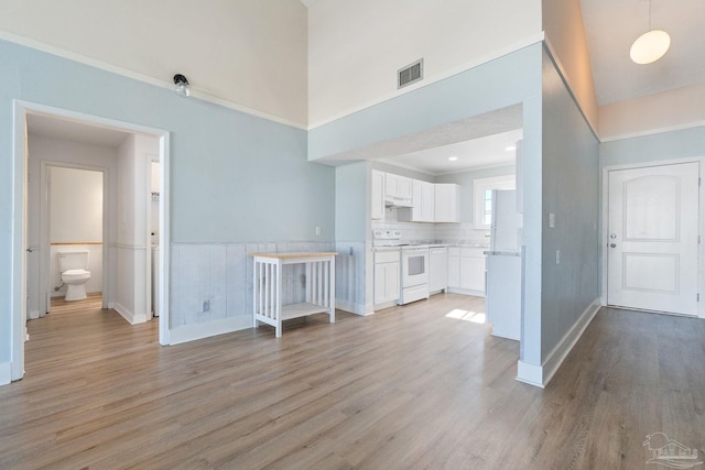 14100 River Rd Unit 324, Pensacola, FL 32507 - unfurnished living room featuring a high ceiling, baseboards, visible vents, and light wood-type flooring