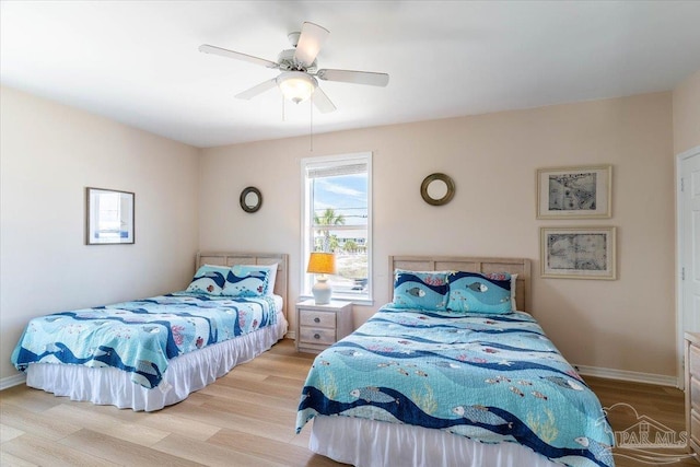 bedroom with baseboards, wood finished floors, and a ceiling fan