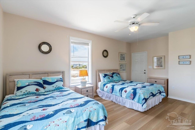 bedroom featuring a ceiling fan, baseboards, and wood finished floors