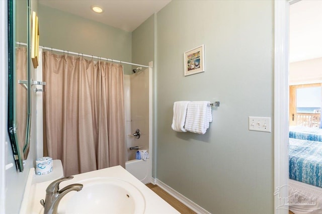 full bath featuring a sink, shower / bathtub combination with curtain, baseboards, and recessed lighting