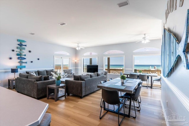 living room with visible vents, ceiling fan, and light wood-style flooring