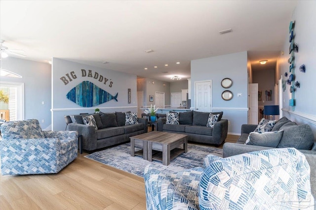 living room featuring wood finished floors, visible vents, and ceiling fan