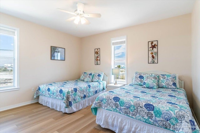 bedroom with ceiling fan, baseboards, and wood finished floors