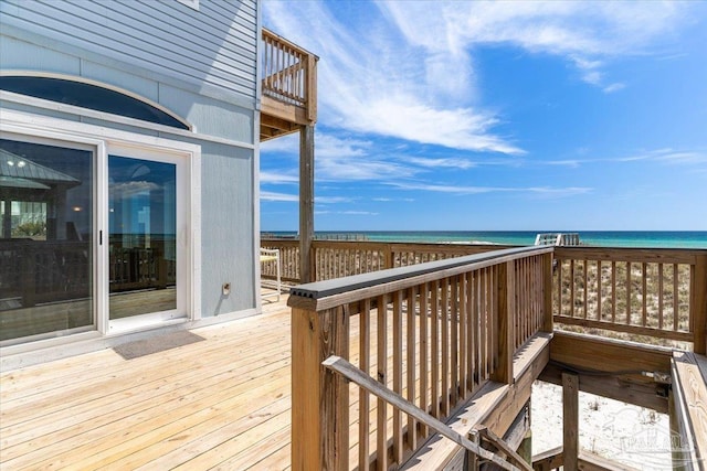 wooden deck featuring a view of the beach and a water view