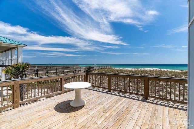 wooden terrace with a water view and a view of the beach