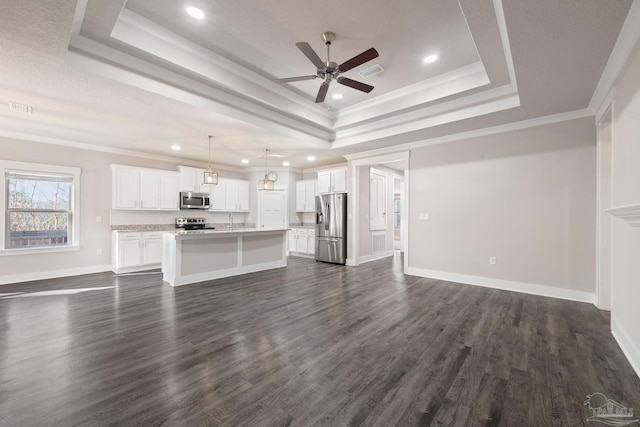 unfurnished living room featuring dark wood finished floors, a raised ceiling, visible vents, and crown molding