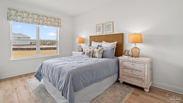 bedroom featuring baseboards and light wood-type flooring