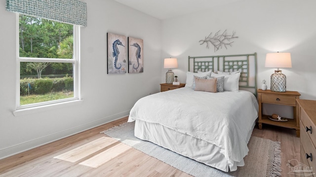 bedroom featuring baseboards and wood finished floors