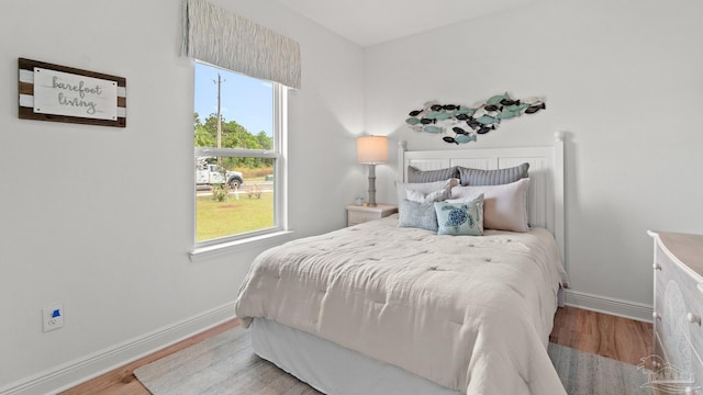 bedroom with baseboards and wood finished floors