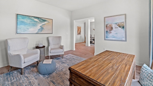 living area with baseboards and wood finished floors