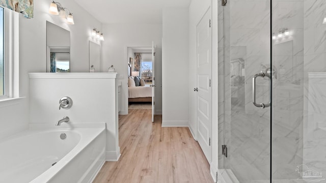 ensuite bathroom featuring a garden tub, connected bathroom, wood finished floors, a stall shower, and baseboards