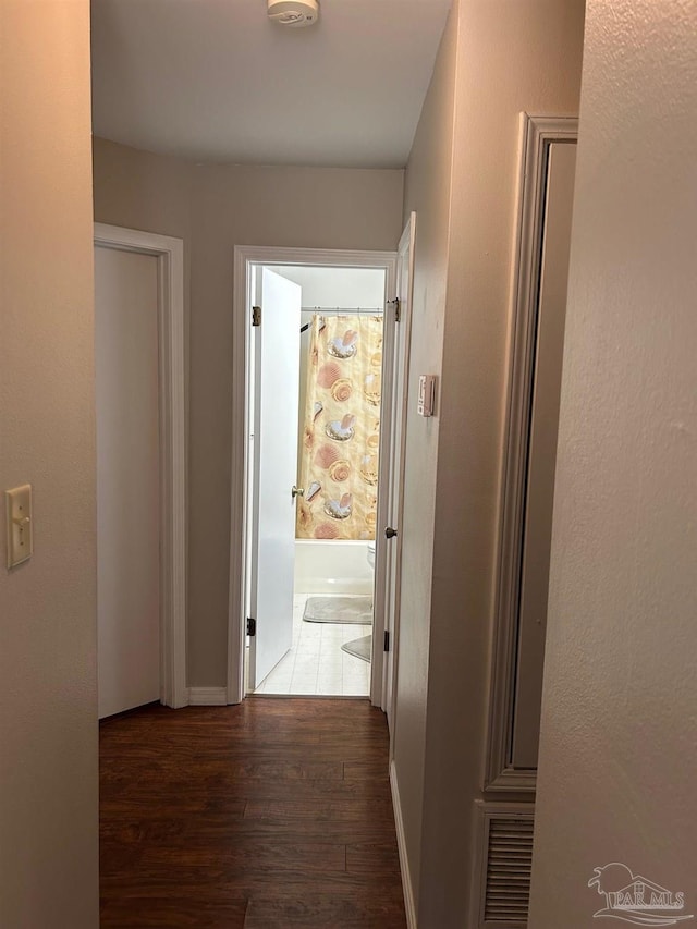 corridor featuring visible vents and wood finished floors