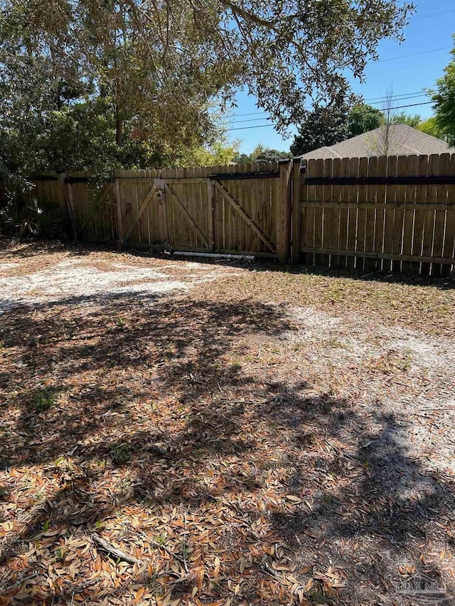 view of yard featuring fence and a gate