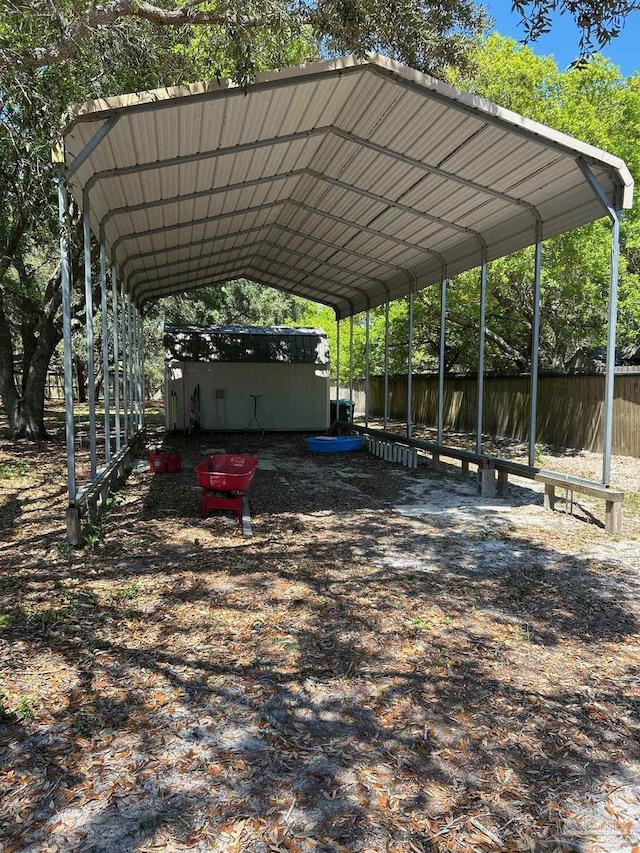 view of parking with a detached carport and fence