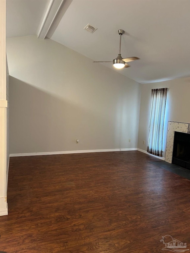 unfurnished living room featuring visible vents, a ceiling fan, a fireplace, dark wood-type flooring, and vaulted ceiling with beams
