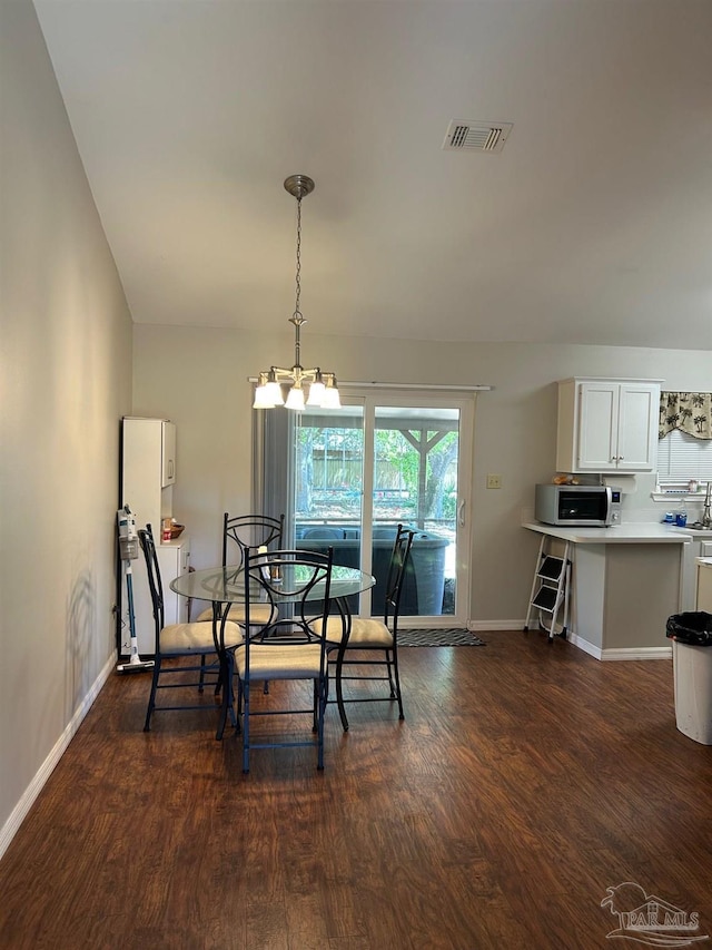 dining room featuring a notable chandelier, visible vents, baseboards, and dark wood finished floors