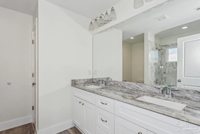 8512 Esplanade St, Navarre, FL 32566 - bathroom with tiled shower, wood finished floors, double vanity, baseboards, and recessed lighting