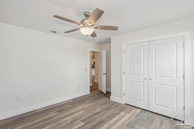 unfurnished bedroom featuring light hardwood / wood-style flooring, a closet, and ceiling fan