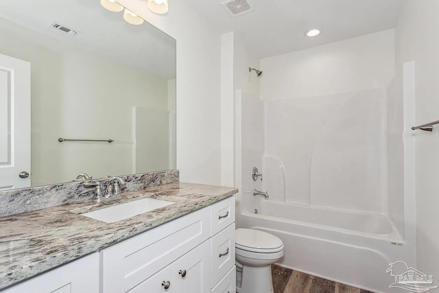 full bathroom with vanity, hardwood / wood-style floors, shower / tub combination, and toilet