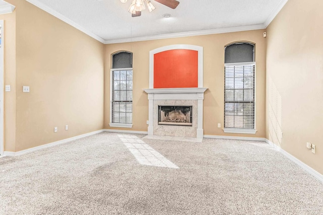 unfurnished living room with crown molding, a fireplace, carpet, and ceiling fan