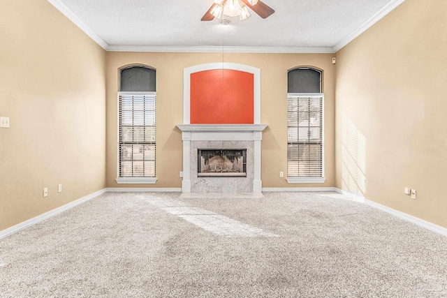 unfurnished living room featuring crown molding, a tile fireplace, carpet, and ceiling fan