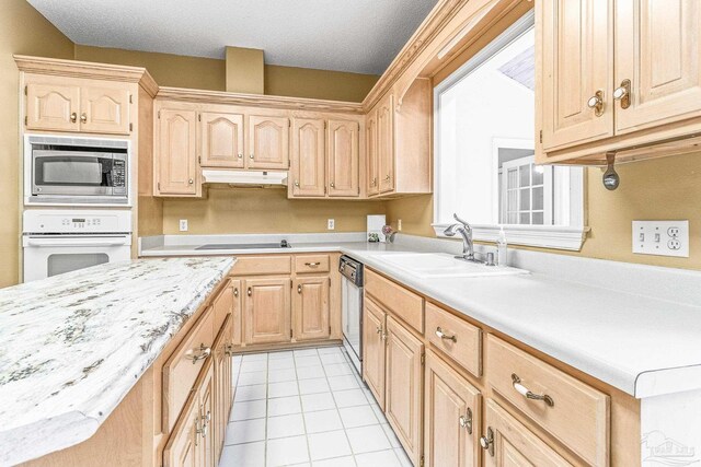 kitchen featuring white oven, sink, light brown cabinets, stainless steel microwave, and light tile patterned floors