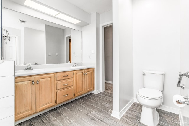 bathroom with double vanity, wood-type flooring, and toilet