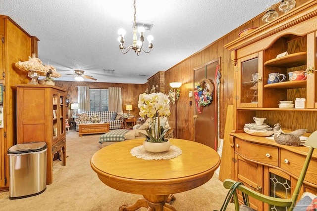 6640 Frank Reeder Rd, Pensacola, FL 32526 - dining space with wooden walls, light colored carpet, a textured ceiling, a chandelier, and ceiling fan