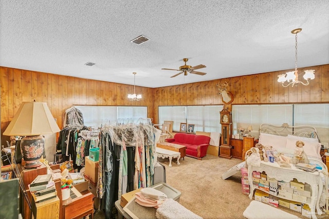 6640 Frank Reeder Rd, Pensacola, FL 32526 - carpeted bedroom with a chandelier, wooden walls, and a textured ceiling