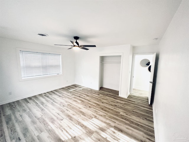 unfurnished bedroom featuring wood-type flooring, a closet, and ceiling fan