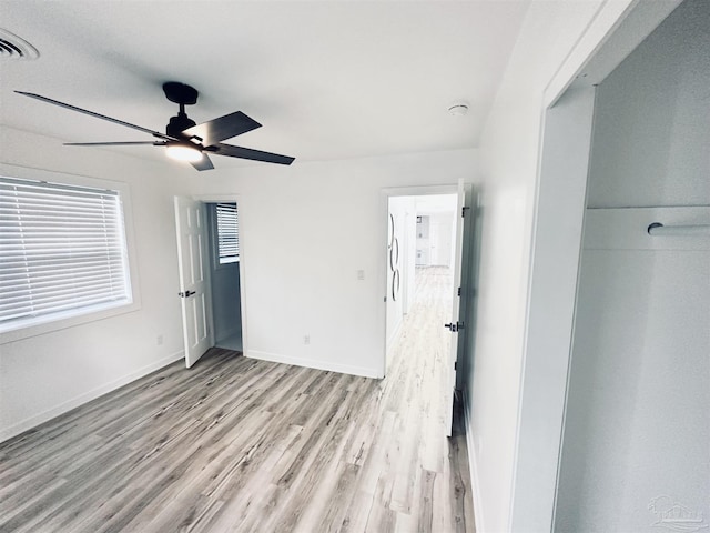 unfurnished bedroom with ceiling fan, a closet, and light hardwood / wood-style flooring