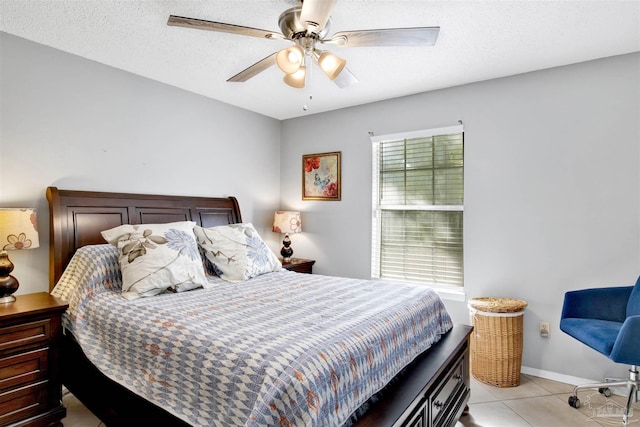 tiled bedroom featuring ceiling fan and a textured ceiling