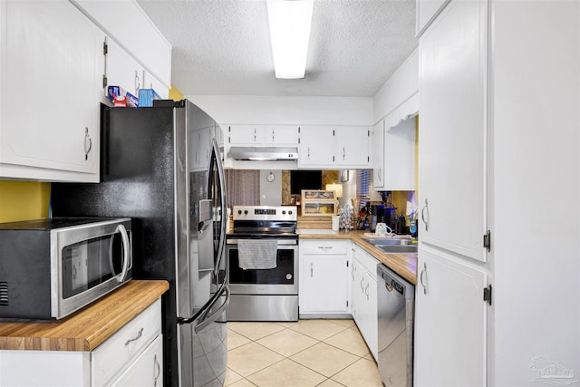 kitchen with white cabinetry, sink, stainless steel appliances, a textured ceiling, and light tile patterned floors