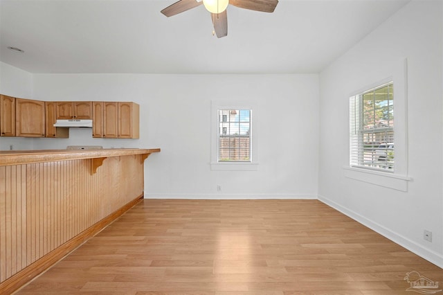 kitchen featuring a kitchen breakfast bar, light hardwood / wood-style floors, and ceiling fan