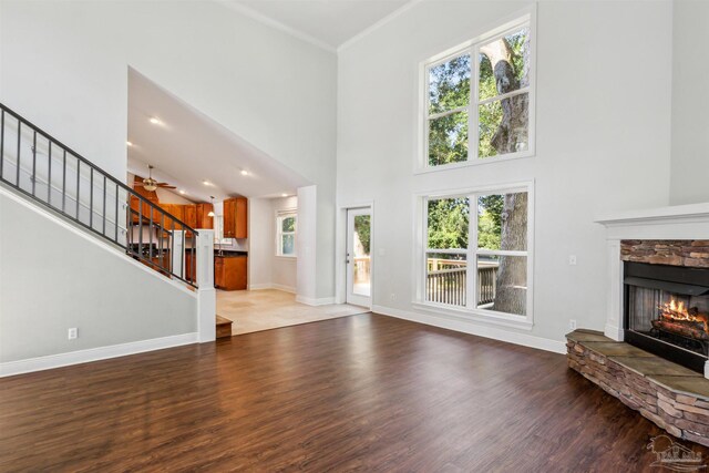 6814 Cedar Lake Dr, Pensacola, FL 32526 - unfurnished living room featuring a stone fireplace, stairway, wood finished floors, and a healthy amount of sunlight