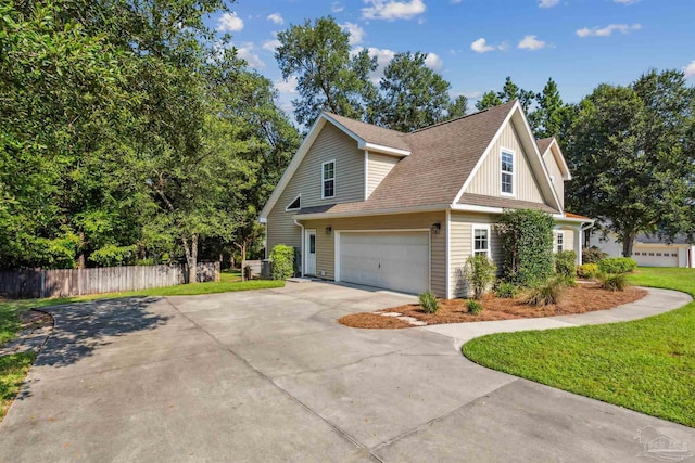 view of home's exterior with roof with shingles, a lawn, an attached garage, fence, and driveway